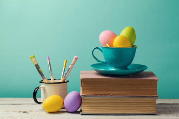 istock Easter holiday celebration with handmade painted eggs in coffee cup. Creative workplace concept 831109620