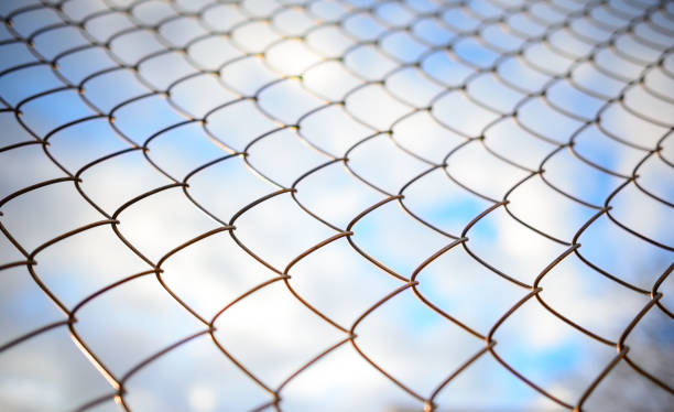 istock Blue sky behind a metal grate 831117010