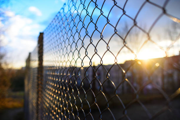 cerca com grelha metálica em perspectiva - barbed wire fence wire danger - fotografias e filmes do acervo