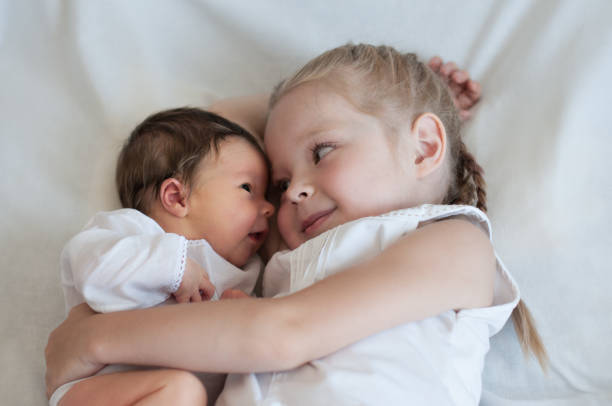 schwester umarmt ihr jüngeren bruder - schwester stock-fotos und bilder