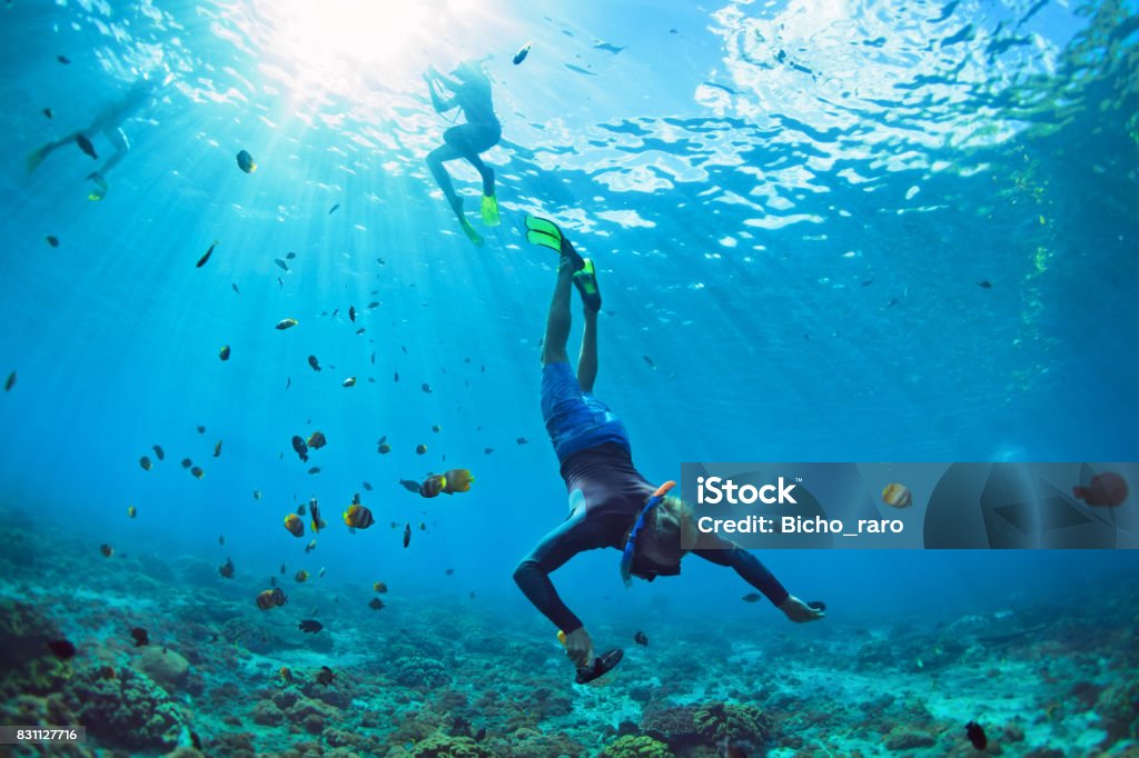 Young man in snorkelling mask dive underwater Happy family vacation. Man in snorkeling mask with camera dive underwater with tropical fishes in coral reef sea pool. Travel lifestyle, water sport outdoor adventure, swimming on summer beach holiday Snorkeling Stock Photo