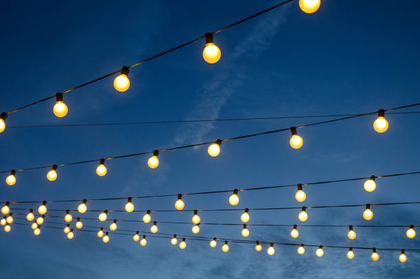 istock Strings of White Lights Glow Against A Blue Sky 831127754