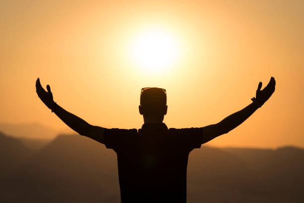 istock Young male against the light open arms at sunset 831142150