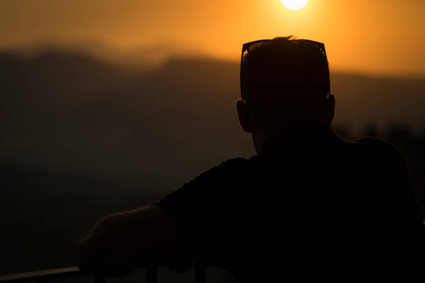 istock Young male looking the views on the cliff at sunset 831146032