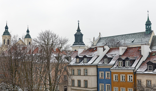 Winter cityscape with old residential buildings and churches in Warsaw, Poland