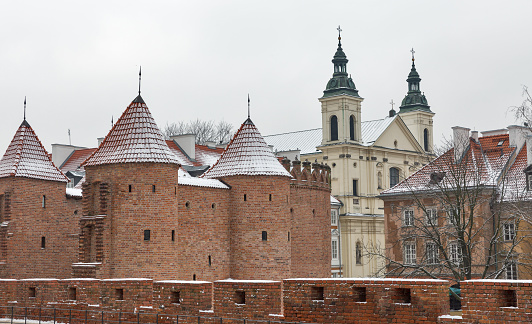 Winter cityscape with military medieval building Barbican and St Spirit and St Paul Pauline Church in Warsaw, Poland