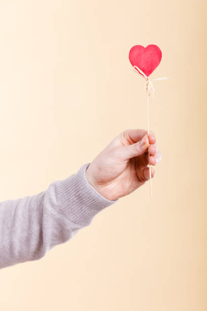 istock Male hand with little heart on stick. 831163892