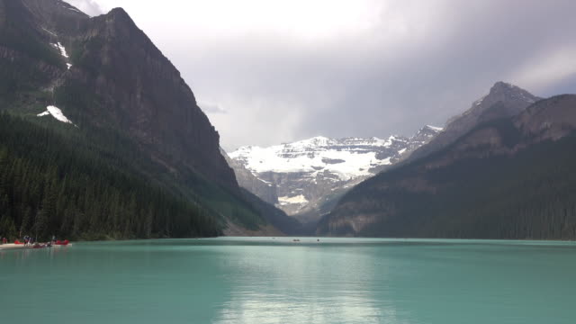 Boaters enjoy turquoise Lake Louise waters Mount Victoria Banff National Park trail