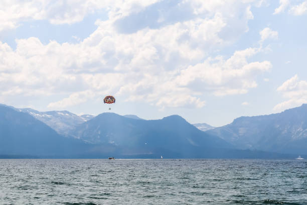 A colorful parachute is flying in the sky above a body of water. The scene is serene and peaceful, with the parachute adding a sense of excitement and adventure to the otherwise calm ocean