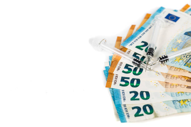 istock Medical syringes on several euro banknotes bills 831187934