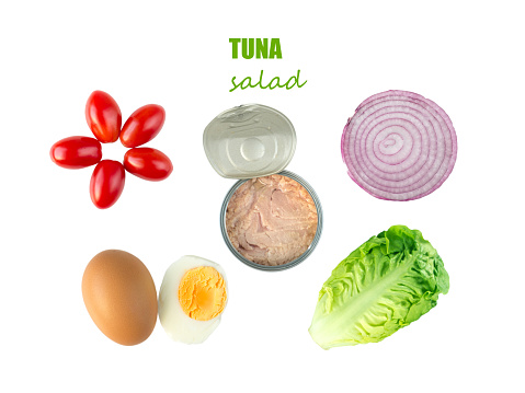 Tuna salad ingredients: baby cos lettuce head, cherry tomatoes, egg ,sweet onion cross section and open tuna can isolated on white