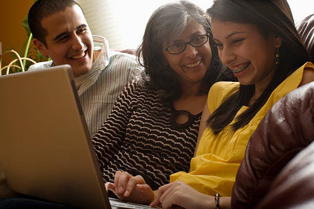 familia sonriente usando computadora portátil - warnock fotografías e imágenes de stock