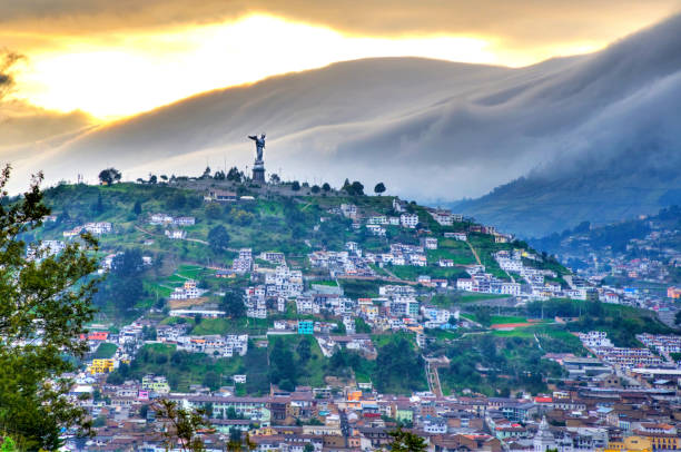 Panecillo hill during a cloudy sunset View of the Panecillo hill with the Virgen Mary statue, with houses and rooftops of downtown Quito, Pichincha, Ecuador, at sunset. quito photos stock pictures, royalty-free photos & images