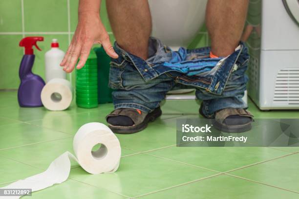 Man Sitting On A Toilet In A Family House Abdominal Pain Diarrhea Stock Photo - Download Image Now