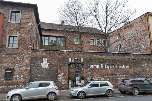 Cars parked in front of Hamsa Israeli restaurant facade in Kazimierz Jewish district. Krakow is the second largest and one of the oldest cities in Poland.