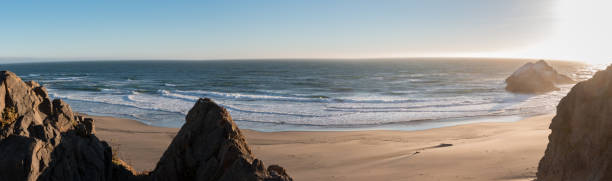 istock Panoramic View of Ocean Waves on Smooth West Coast Beach with Rocks in the Foreground 831213758