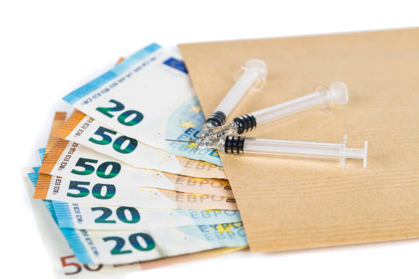 istock Medical syringes on several euro banknotes bills 831220218