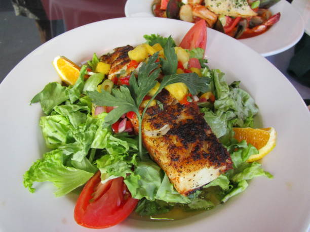 Grilled Salmon Salad Mixed Green Salad of Lettuce, Tomato, Orange Slices, Red Onions, Topped with a Large Charred Fillet of Grilled Pink Salmon caesar salad food salad tuna stock pictures, royalty-free photos & images