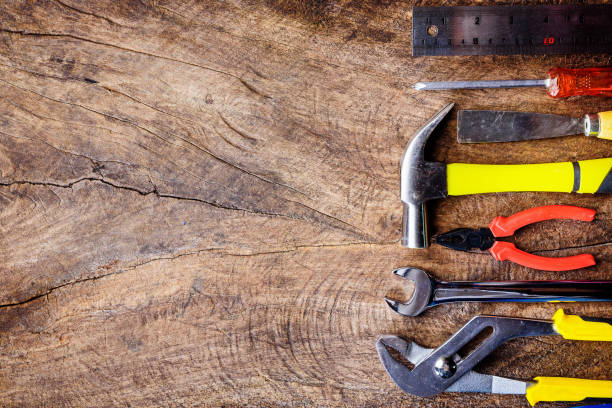 istock Top view of Working construction tools,wrench,hammer,screwdriver,plier,electric drill,tape measure,machinist square on wooden rustic background. flat lay design. 831242142