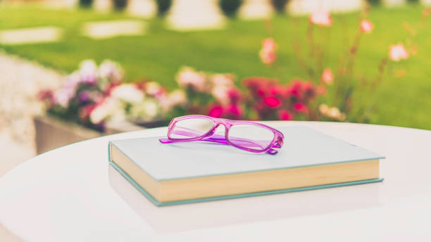 Summer reading. Book and eyeglasses in outdoor setting