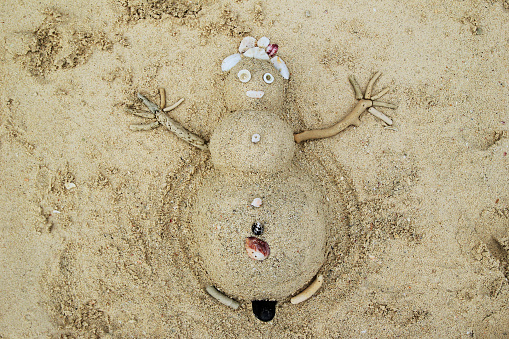 Travel to Phi-Phi island, Thailand. A snowman from sand and seashells on a beach.