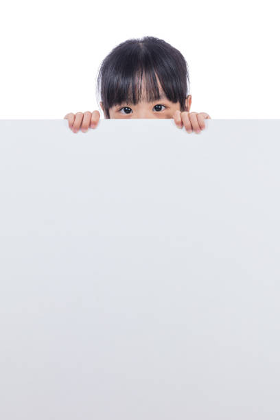 istock Asian Chinese little girl peeping behind white board 831256874
