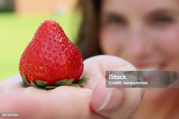 Woman Holds One Strawberry Stock Photo - Download Image Now - Fruit, Headshot, Healthy Eating
