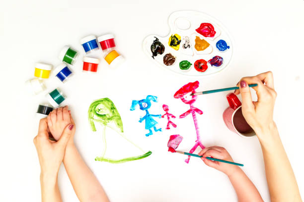 istock Child's hands painting a family 831270654