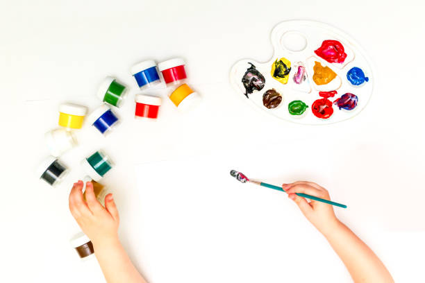 istock Child's hands painting a flower 831270684