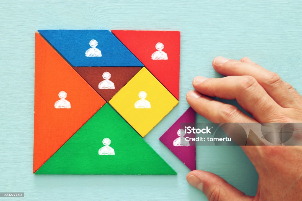 tangram puzzle blocks with people icons ,human resources and management concept. image of tangram puzzle blocks with people icons over wooden table ,human resources and management concept. Recruitment Stock Photo