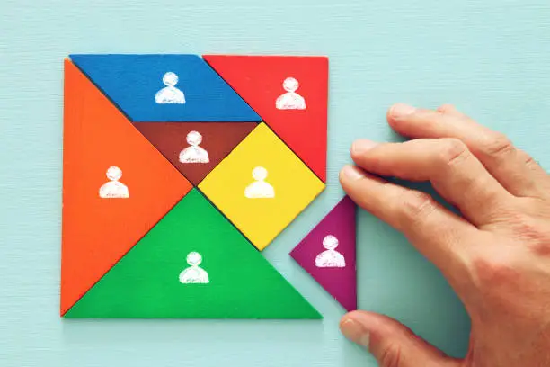 Photo of tangram puzzle blocks with people icons ,human resources and management concept.