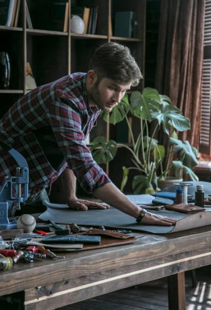 istock Young man leather maker begins work with piece of leather 831287814