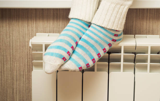 istock Female feet on a central heating radiator 831291110