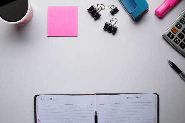 istock Top view of copy space of white working table work space with notebook, cup,note paper,pencil,clip,calculator and other supplies. 831291814