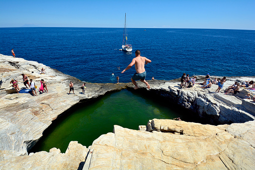Man in swimming trunks jumping into the sea