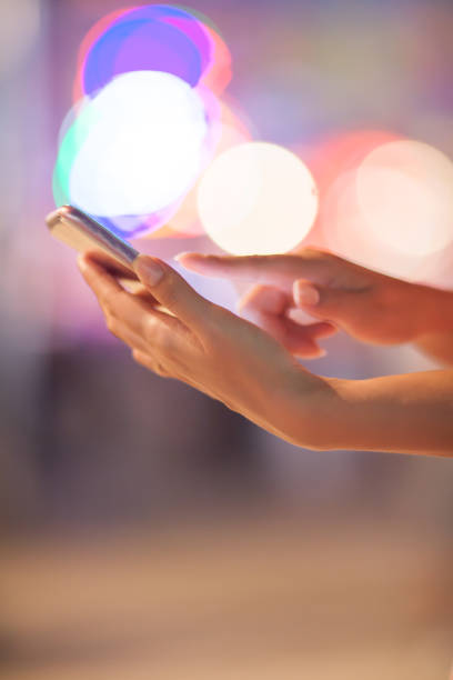 istock Woman using her mobile phone, city skyline night light background 831314234