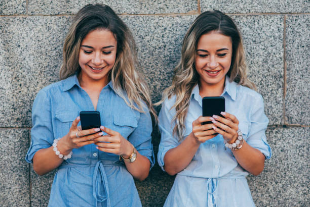 istock Twins texting in the city 831326298