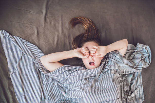 istock Beautiful young woman lying down in bed and sleeping, top view. Do not get enough sleep concept 831333128