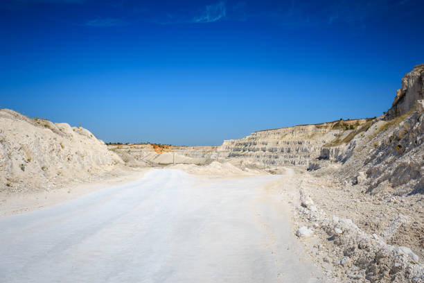 Road to quarry. Limestone mining. White rocks, bright blue sky