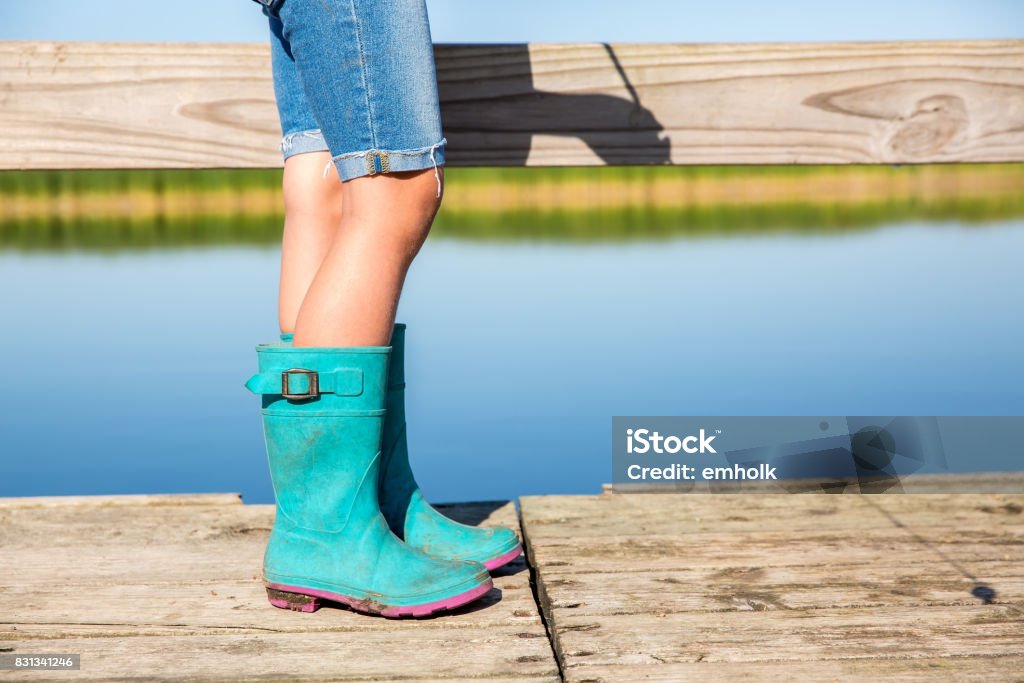 Waist Down View Of Girl Fishing With Shorts Rubber Boots Stock