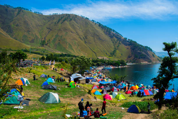 Activities 1000 Tents at the Edge of Lake Toba Hundreds of tents appear to be traced on the edge of the lake with green water around Paropo Island, in Silalahi Village, Silahisabungan Subdistrict, North Sumatra. danau toba lake stock pictures, royalty-free photos & images