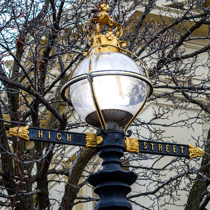 A lamppost in Northcote, Victoria, Australia featuring a glass dome light, and High Street name in gold lettering. Also featuring a golden Queen Elizabeth crown on top.