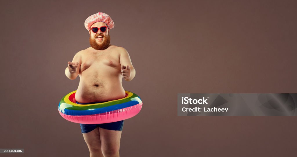 Hombre gordo gracioso en un anillo inflable. - Foto de stock de Humor libre de derechos