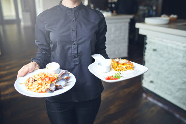 istock Waiters carrying plates with food, in a restaurant. 831349716