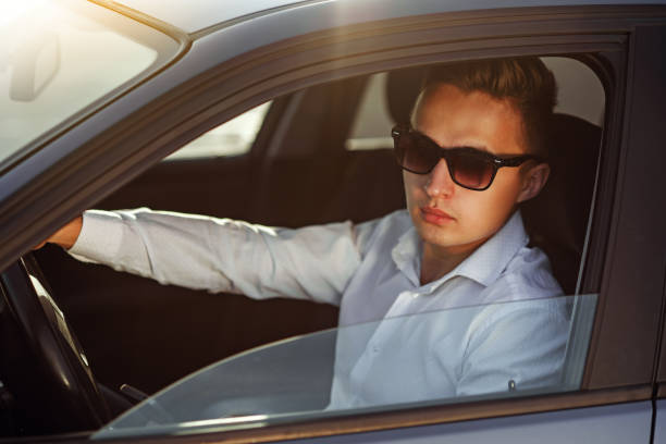 istock Attractive handsome man in sunglasses driving his car 831352098