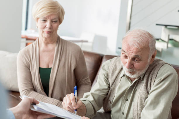 istock Senior couple signing financial papers 831356382