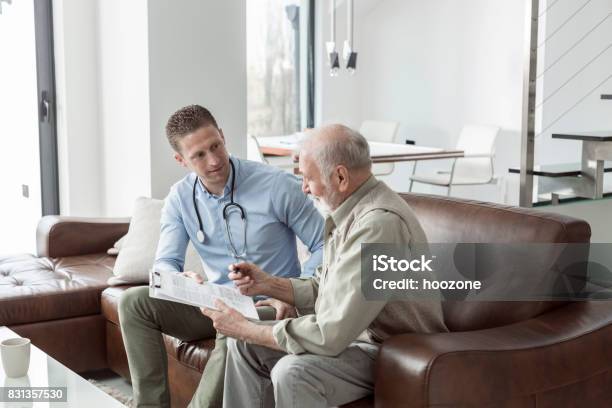 Senior Man On Meeting With Insurance Agent At Home Stock Photo - Download Image Now - Healthcare And Medicine, Savings, Plan - Document