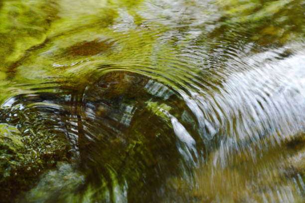 acqua che scorre ha colpito la roccia e increspato - indirection foto e immagini stock