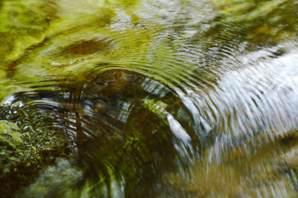 water flowing hit the rock and rippled - indirection imagens e fotografias de stock