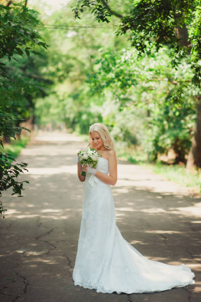 istock Beautiful bride with a bouquet in the park 831364030